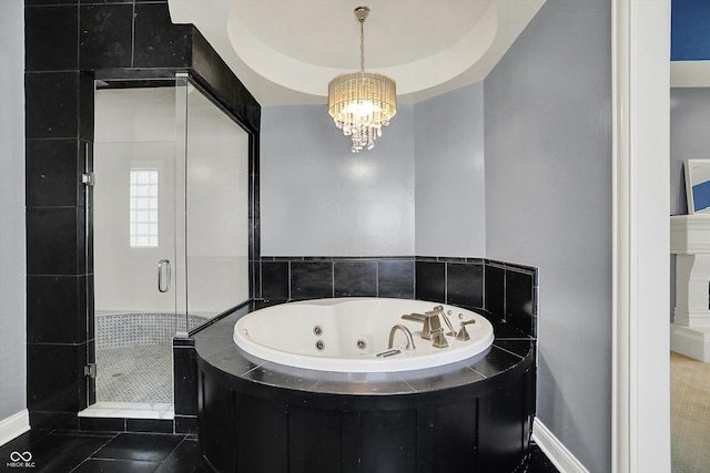 full bathroom featuring an inviting chandelier, baseboards, a tub with jets, and a shower stall