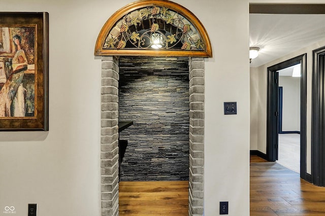 hall featuring baseboards and wood finished floors