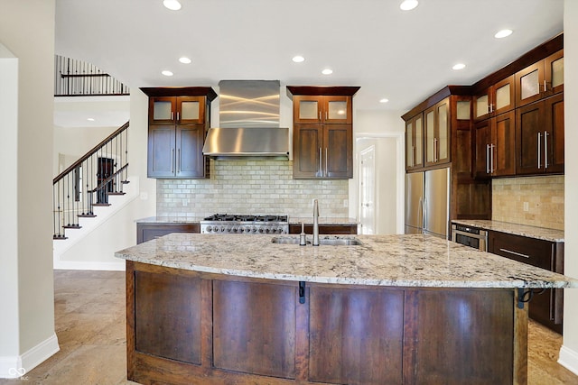 kitchen with wall chimney range hood, stainless steel fridge, a sink, recessed lighting, and baseboards
