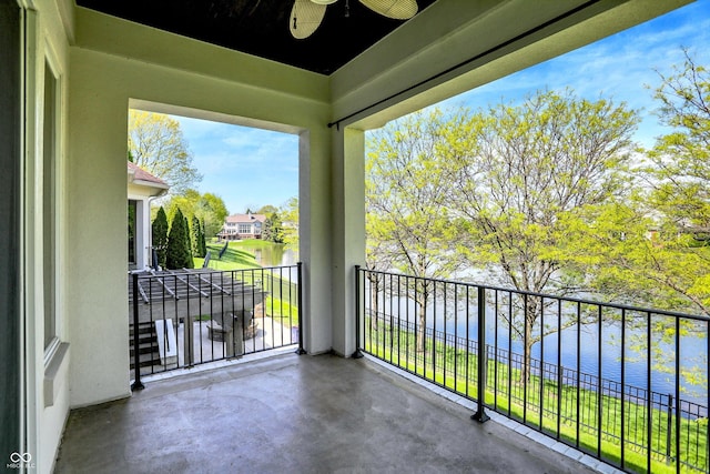 balcony with a ceiling fan and a water view