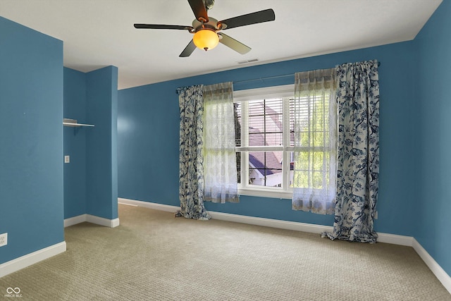unfurnished room with baseboards, a ceiling fan, carpet flooring, and visible vents
