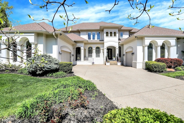 mediterranean / spanish home featuring a garage, stucco siding, a shingled roof, and concrete driveway