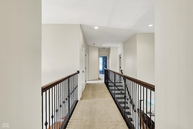 corridor with baseboards, light carpet, recessed lighting, and an upstairs landing