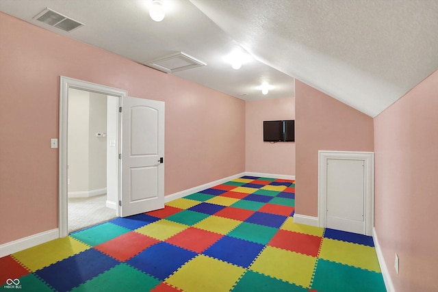 recreation room featuring visible vents, baseboards, lofted ceiling, and tile patterned floors