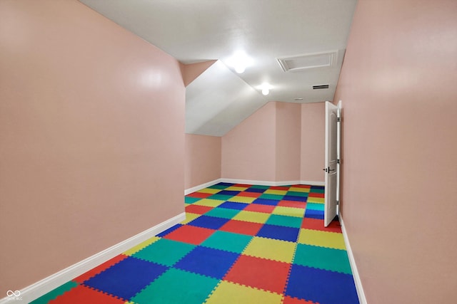 game room featuring baseboards, vaulted ceiling, and visible vents