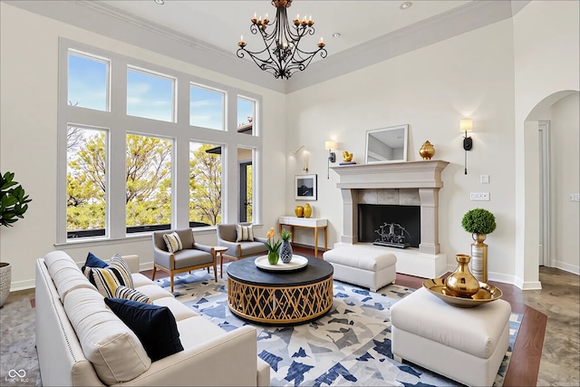 living room featuring arched walkways, baseboards, a chandelier, and a high ceiling