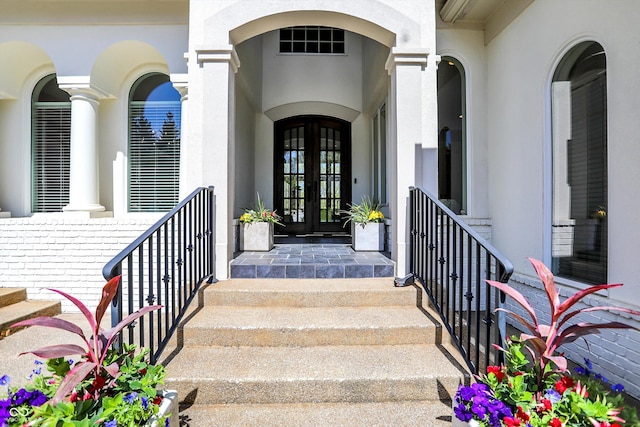 doorway to property featuring visible vents, french doors, and stucco siding