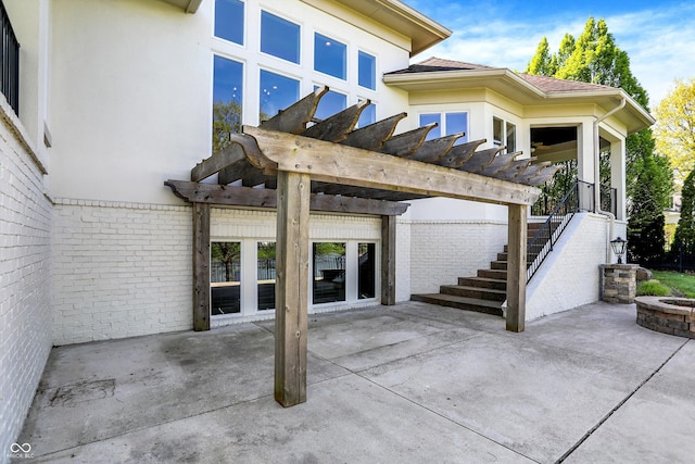 exterior space featuring a pergola, a fire pit, a patio area, and brick siding