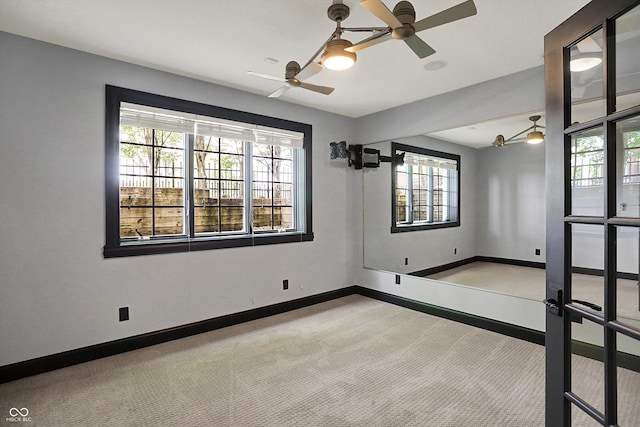 empty room featuring plenty of natural light, carpet flooring, and ceiling fan
