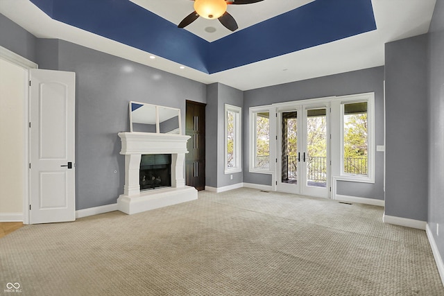 unfurnished living room featuring french doors, carpet, ceiling fan, and baseboards