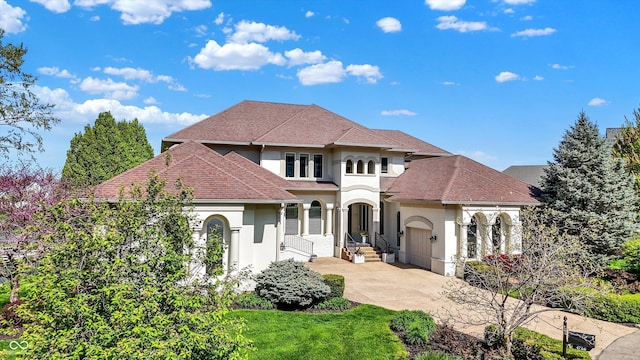 mediterranean / spanish home featuring a shingled roof and stucco siding
