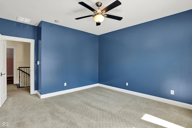 unfurnished room featuring carpet flooring, ceiling fan, visible vents, and baseboards