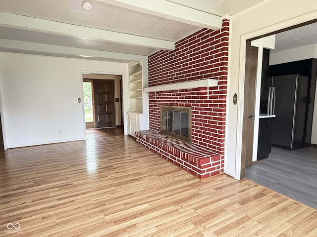 645 Boulder Rd, Indianapolis, IN 46217 - unfurnished living room with built in features, a brick fireplace, baseboards, beamed ceiling, and light wood-style floors