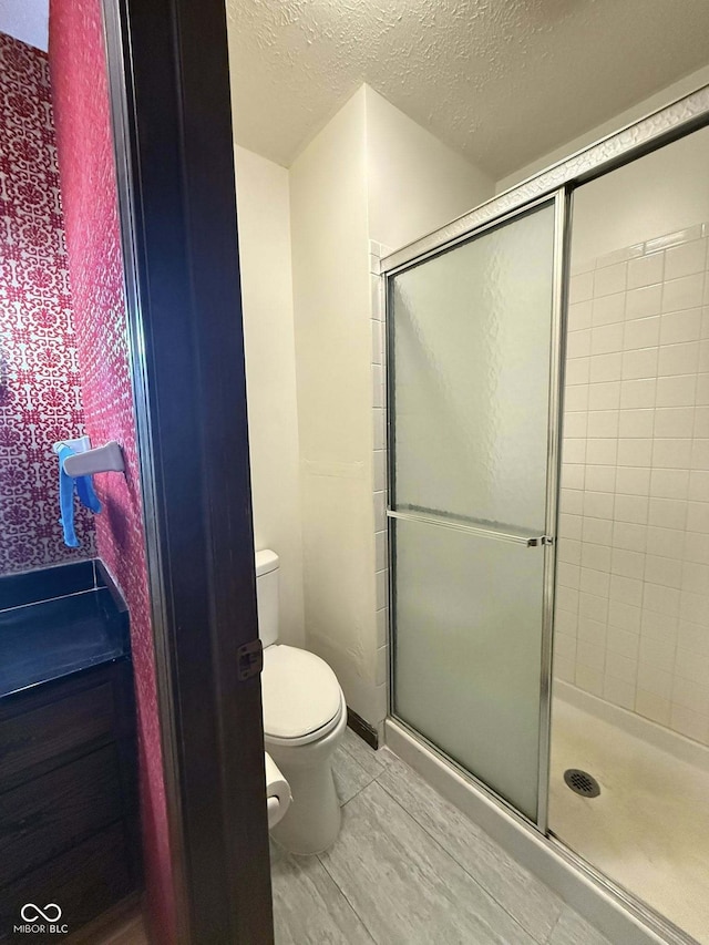 645 Boulder Rd, Indianapolis, IN 46217 - bathroom with a stall shower, toilet, and a textured ceiling