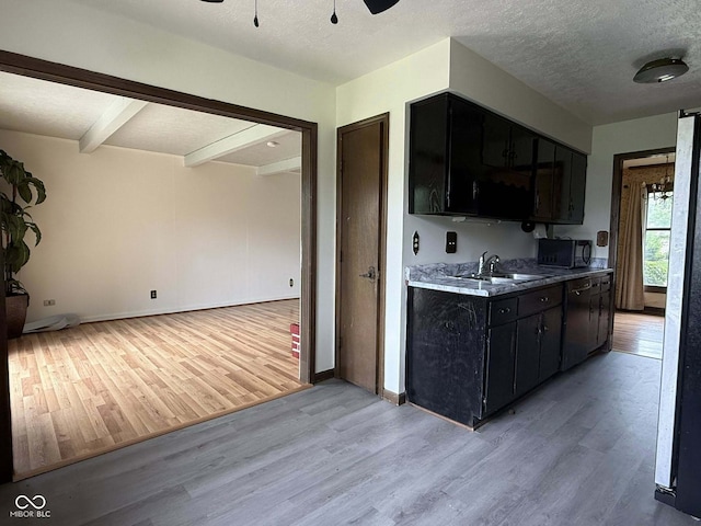 645 Boulder Rd, Indianapolis, IN 46217 - kitchen with light wood-style floors, a ceiling fan, a sink, black appliances, and dark cabinets