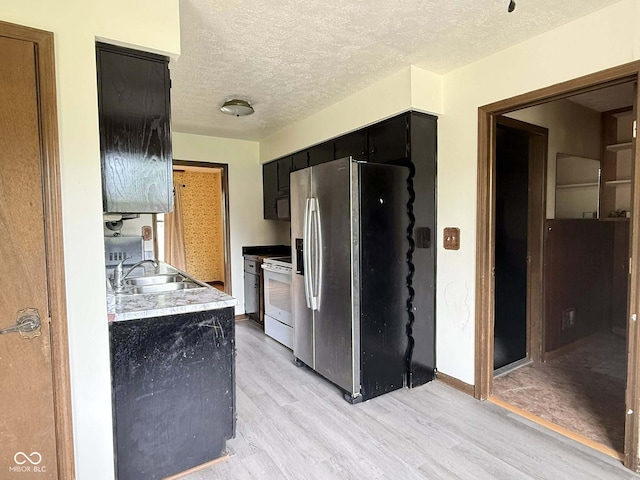 645 Boulder Rd, Indianapolis, IN 46217 - kitchen featuring white range with electric cooktop, light wood-style floors, stainless steel refrigerator with ice dispenser, dark cabinets, and a sink