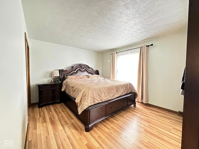 645 Boulder Rd, Indianapolis, IN 46217 - bedroom with baseboards, light wood-type flooring, and a textured ceiling