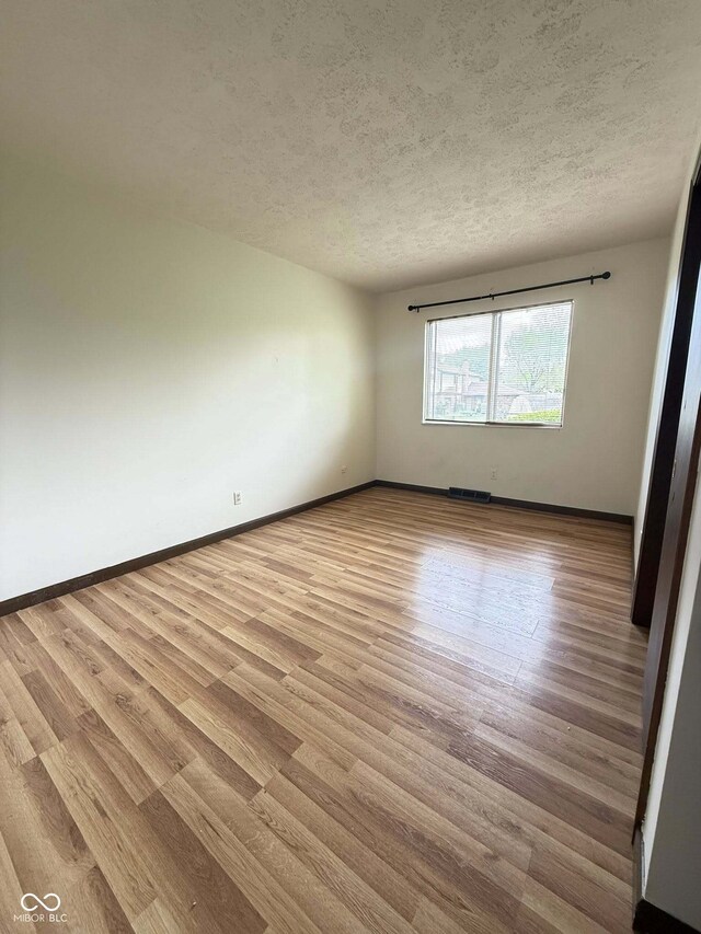 645 Boulder Rd, Indianapolis, IN 46217 - empty room featuring baseboards, a textured ceiling, and wood finished floors