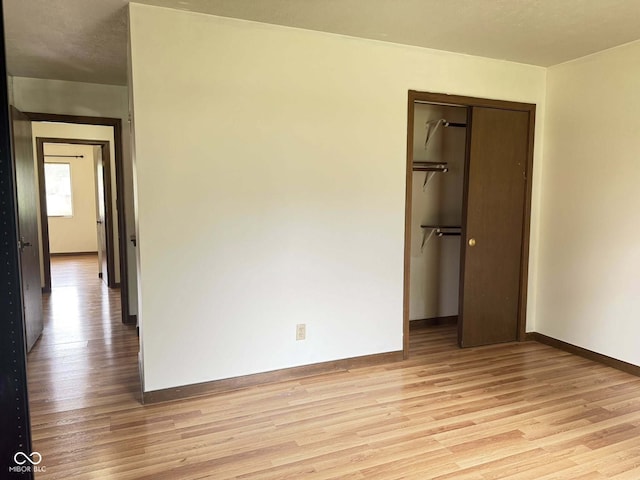 645 Boulder Rd, Indianapolis, IN 46217 - unfurnished bedroom featuring a closet, baseboards, and light wood-type flooring