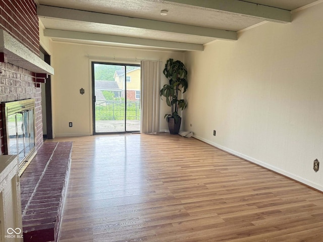 645 Boulder Rd, Indianapolis, IN 46217 - unfurnished living room featuring baseboards, a fireplace, beam ceiling, and wood finished floors