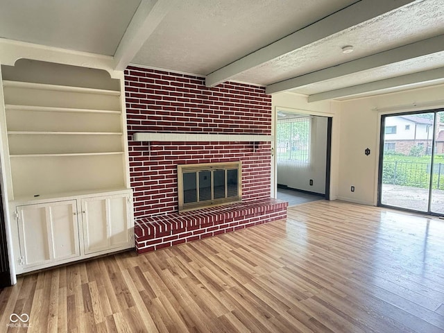 645 Boulder Rd, Indianapolis, IN 46217 - unfurnished living room with a textured ceiling, plenty of natural light, beam ceiling, and wood finished floors
