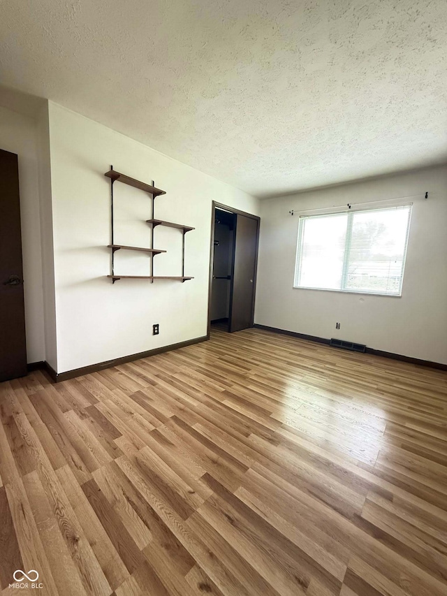 645 Boulder Rd, Indianapolis, IN 46217 - unfurnished living room with baseboards, a textured ceiling, and wood finished floors