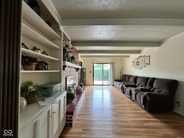 645 Boulder Rd, Indianapolis, IN 46217 - living area featuring a textured ceiling, beamed ceiling, a brick fireplace, and wood finished floors