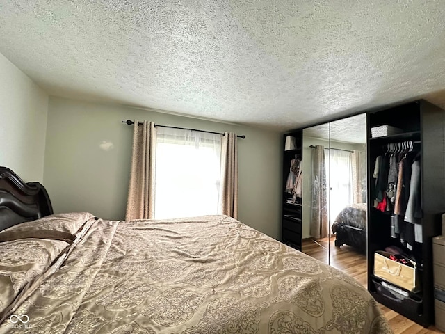 645 Boulder Rd, Indianapolis, IN 46217 - bedroom featuring a closet, a textured ceiling, and wood finished floors