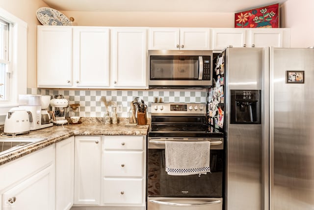 4406 Carrollton Ave, Indianapolis, IN 46205 - kitchen with stainless steel appliances, white cabinets, and light stone countertops
