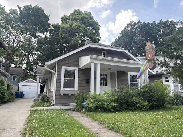 4406 Carrollton Ave, Indianapolis, IN 46205 - bungalow-style home featuring an outbuilding, a chimney, driveway, and a detached garage
