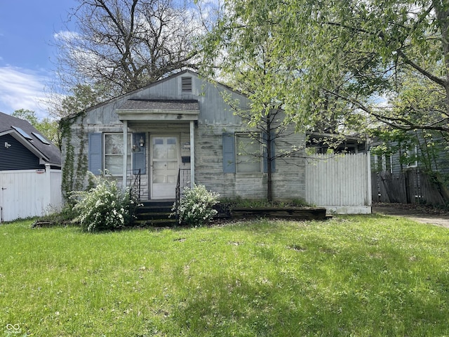 view of front of home featuring fence and a front lawn
