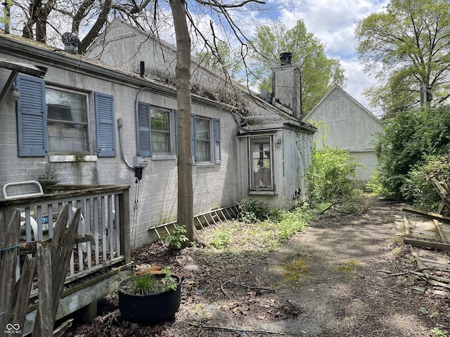 exterior space with brick siding and a chimney