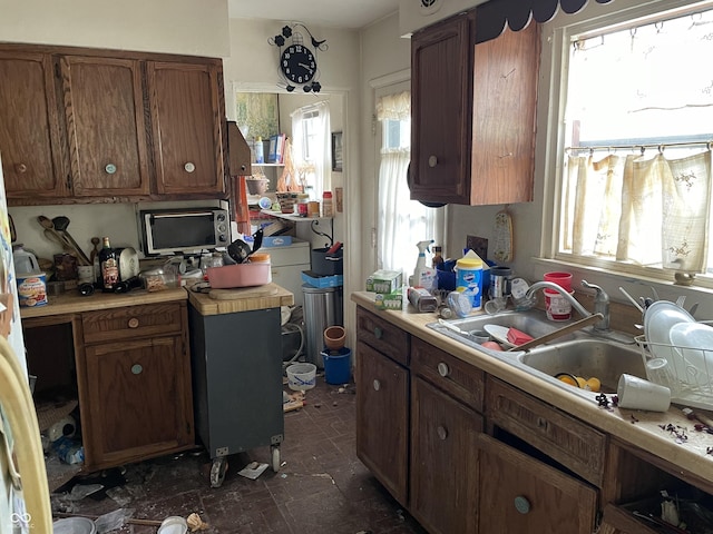 kitchen with light countertops, a sink, and brown cabinets