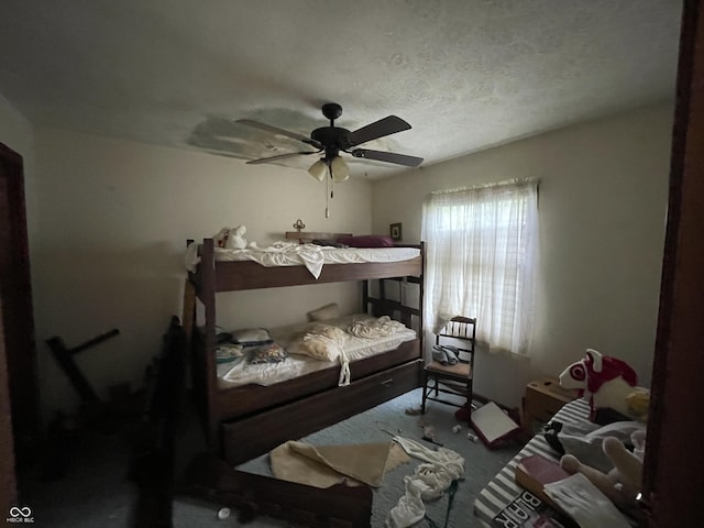 bedroom featuring carpet, a ceiling fan, and a textured ceiling