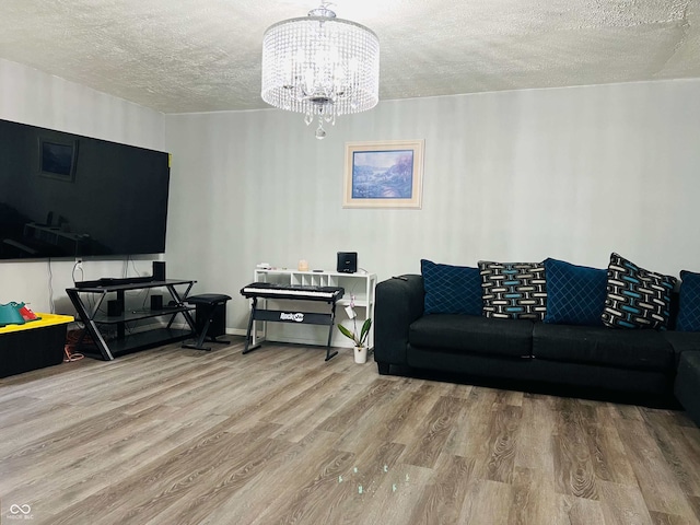 living room with a textured ceiling, wood finished floors, and a chandelier