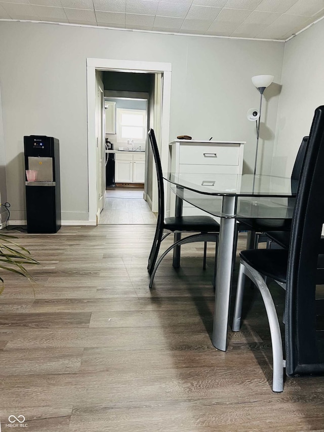 dining space featuring baseboards and light wood-style flooring