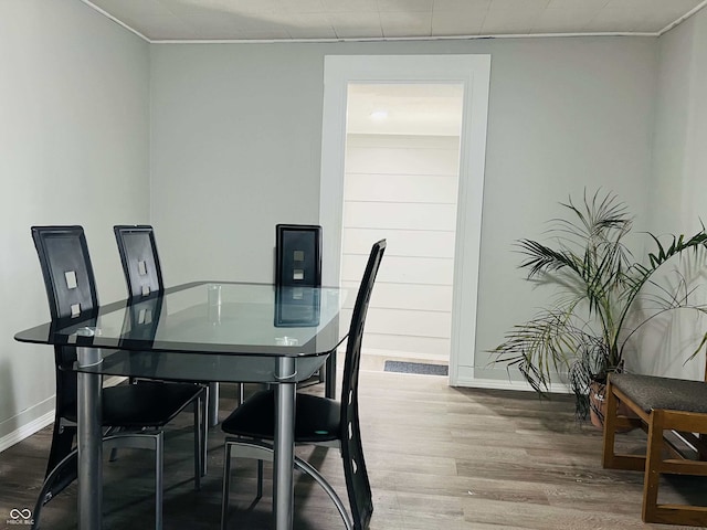 dining space featuring crown molding, baseboards, and wood finished floors
