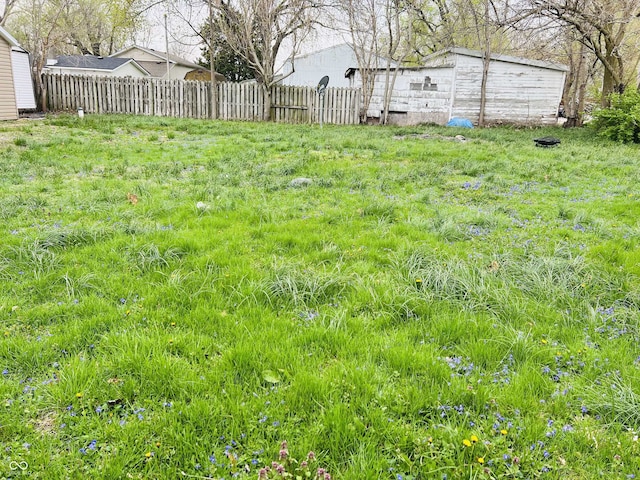 view of yard featuring fence and an outbuilding