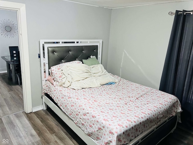 bedroom with baseboards and wood finished floors