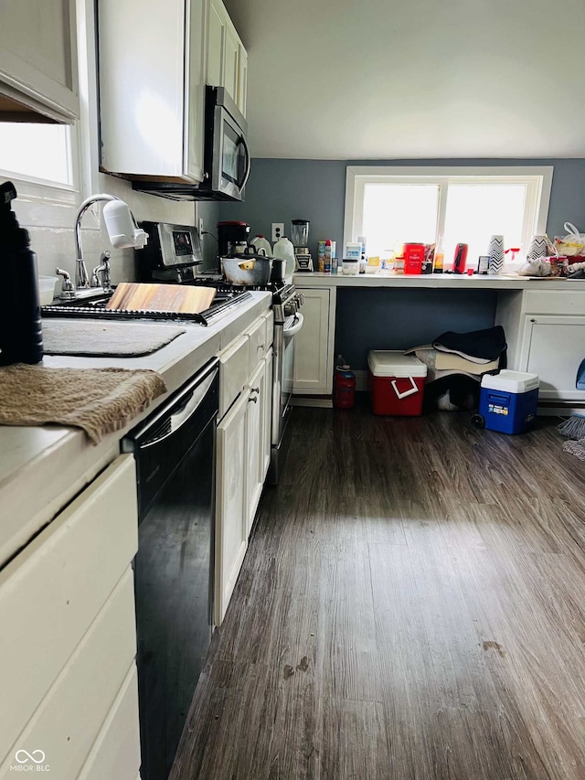 kitchen featuring dark wood-style flooring, stainless steel appliances, white cabinetry, and a healthy amount of sunlight