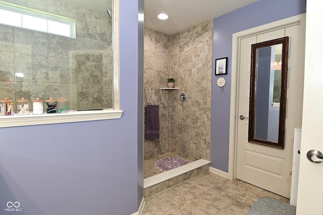 bathroom featuring baseboards and tiled shower