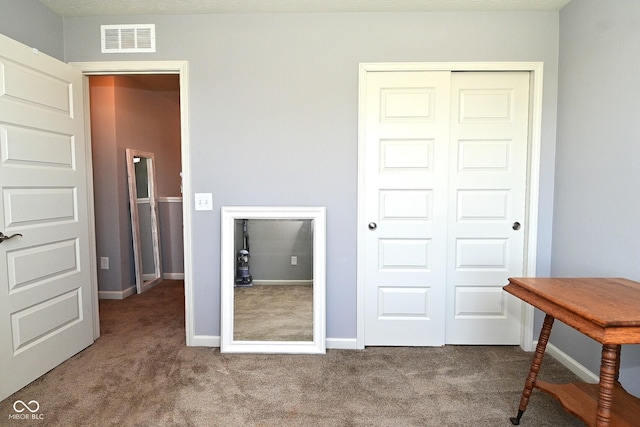 bedroom with visible vents, carpet, baseboards, and a closet