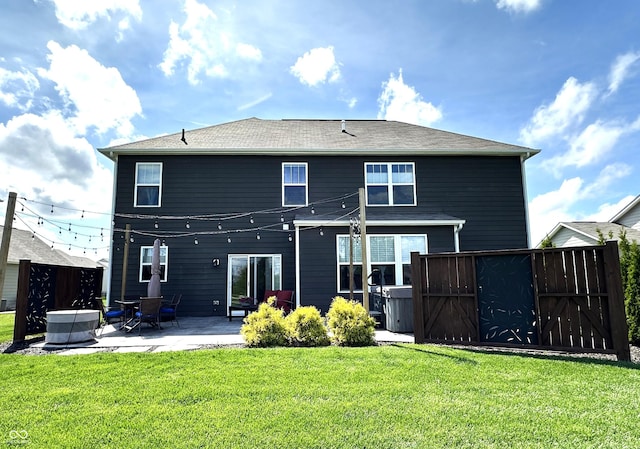 back of property featuring a lawn, a patio, and fence