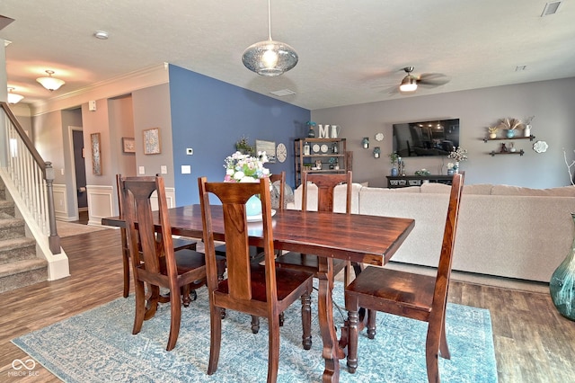 dining room featuring stairs, ceiling fan, visible vents, and wood finished floors