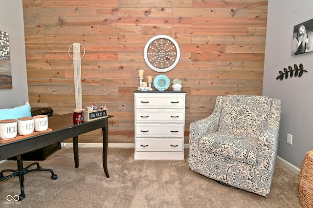 office area featuring wooden walls, baseboards, and light carpet