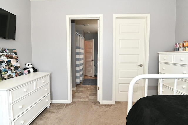 bedroom featuring baseboards and light carpet