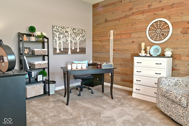 office area featuring baseboards, light carpet, and wood walls