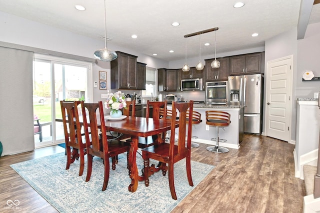 dining space with recessed lighting, wood finished floors, and a toaster