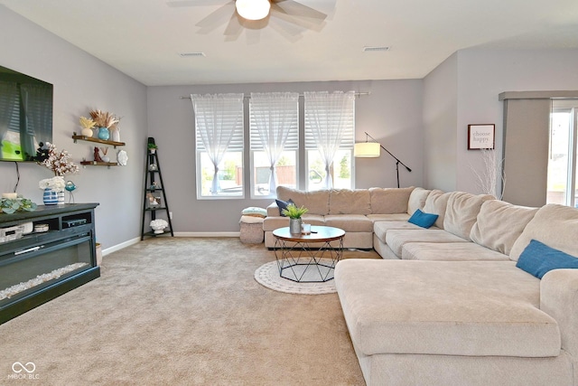 carpeted living area with baseboards, ceiling fan, and visible vents