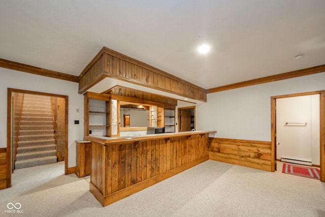 bar featuring crown molding, light colored carpet, baseboard heating, wood walls, and stairway